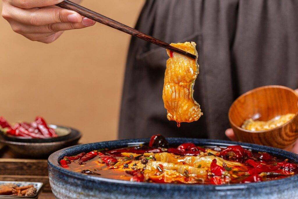 Hot pot with person picking up food with chopsticks